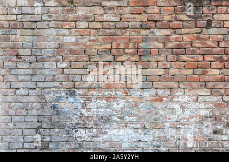 Background of old vintage dirty brick wall with peeling plaster, texture Stock Photo