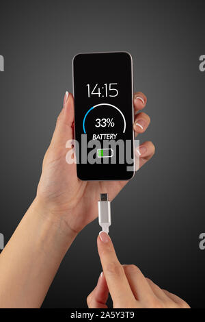 Elegant hand charging cellphone with low battery Stock Photo