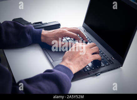 Hackers are logged in with password. On blank screen There is a gun on the side. Stock Photo