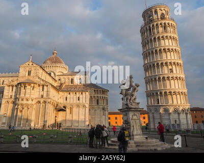 Historic center of Pisa. Leaning Tower, fountain with Angels or Fontana dei Putti marble baroque sculpture. Cathedral or Duomo di Santa Maria Assunta.