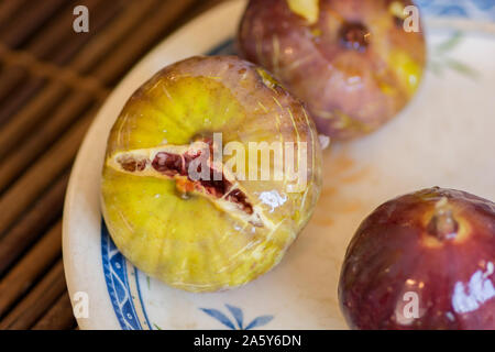 Close up view of ripe common figs (Ficus carica) fruits, served in a blue and white plate Stock Photo