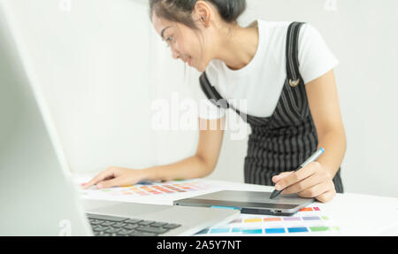 Graphic designer at work. Color swatch samples. Artist drawing something on graphic tablet at the office. Graphic designer creativity editor ideas des Stock Photo