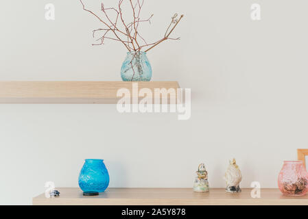 Light shelf on the wall with decor. A branch in a vase. Scandinavian minimalism in the interior Stock Photo