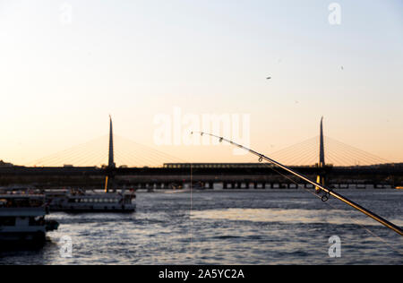 Still life image of a fishing rod with view of the Metro Bridge at the Golden Horn, Istanbul. Stock Photo