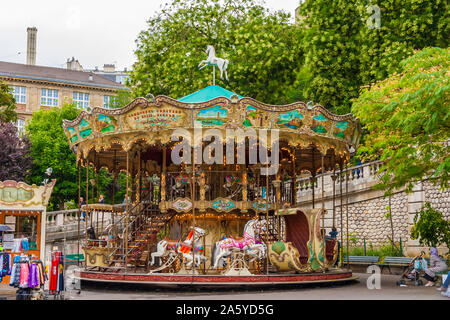 A lovely French old-fashioned style carousel with rows of wooden horses mounted on posts and a staircase to the second floor in the Louise Michel... Stock Photo