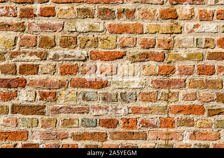 Section of a masonry wall with bricks in a large variety of colors, from red and brown to yellow and white and even blue Stock Photo