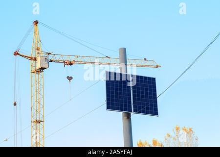 Solar panel on top electric pole by blue sky. Small photovoltaic panel at city street Stock Photo