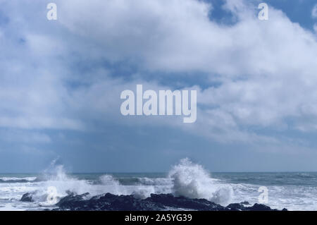 cloudscape over sea with waves collididng lava rock on Jeju Island Stock Photo