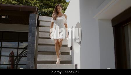 Charming woman walking down stairs Stock Photo