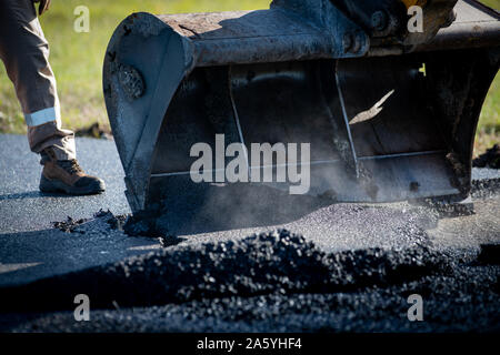 Laying fresh asphalt on construction site on a road Stock Photo