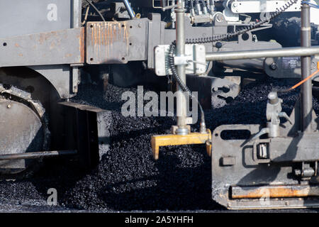 Laying fresh asphalt on construction site on a road Stock Photo