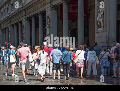 visitors tourists tour groups group waiting queueing in line to enter the famous historic uffizi gallery art museum in florence italy. Stock Photo