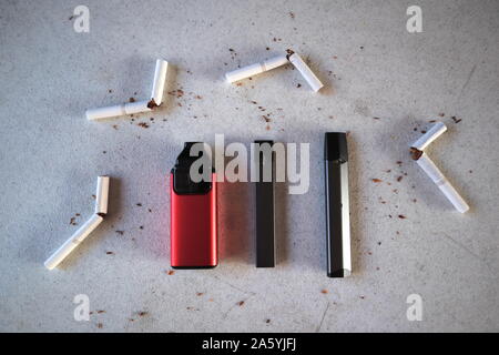 Different vape devices electronic cigarettes juul, aspire breeze, smok  infinix, as smoking alternatives with broken marlboro gold cigarettes and  scatt Stock Photo