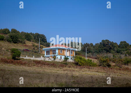 Turquoise colored two storey house in the distance view Stock Photo