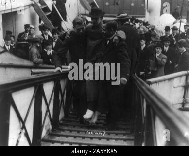 Loss of White Star Line's Olympic-class vessel RMS Titanic which struck an iceberg on 12 April 1912 on her maiden voyage. Surviving wireless operator, Harold Bride, feet bandaged, being carried up gangway, New York. Disaster Stock Photo