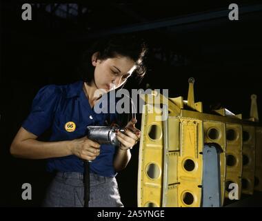 American female engineer during World War II, drilling horizontal stabilizers using operating a hand drill. , The woman is working on the horizontal stabilizer for a Vultee 'Vengeance' dive bomber, Tennessee. The 'Vengeance' (A-31) 1943 rom U.S. Office of War Information, 1944 Stock Photo