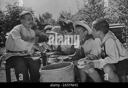 Altai territory, Central Asia, USSR (Union of Soviet Socialist Republics). Children on a collective farm tasting honey. between 1930 and 1940 Stock Photo