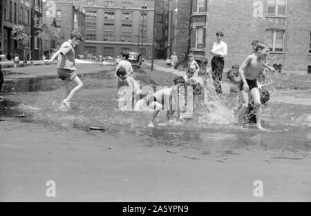 Untitled photo, possibly related to: Cooling off in water from hydrant, Chicago, Illinois. Creator John Vachon, 1914-1975. 1943. Stock Photo