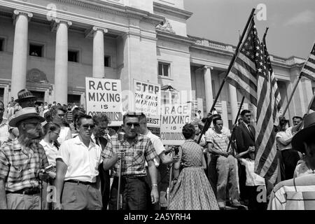 White segregationist demonstrators protesting at the admission of the Little Rock Nine, to Central High School; 1959. The Little Rock Nine were a group of nine African American students enrolled in Little Rock Central High School in 1957. Their enrolment was followed by the Little Rock Crisis, in which the student were initially prevented from entering the racially segregated school by Orval Faubus, the Governor of Arkansas. They then attended after the intervention of President Dwight D. Eisenhower Stock Photo