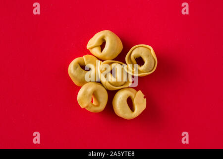Fresh tortellini pasta isolated on red background Stock Photo