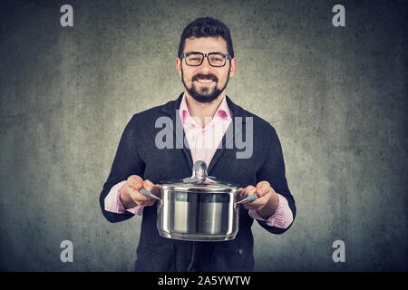 Happy handsome man with cooking pot looking at camera Stock Photo