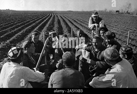 Photograph of Uzbek collective farmers discussing work of spring sowing in the USSR. Dated 1941 Stock Photo