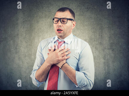 Young business man having asthma attack or chest pain Stock Photo