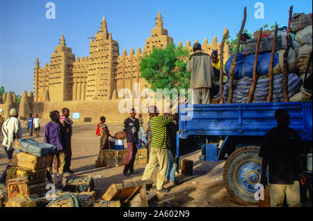 Djenne, Mali; men load their lorry after market day in front of the Great Mosque Stock Photo