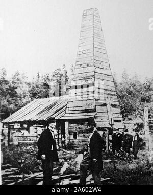 Drake Well, Pennsylvania. Colonel Edwin Laurentine Drake (1819-1880), centre, talking to his engineer. Labourers who ank the well stand in the background. Stock Photo