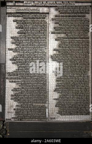 Metal plate with letters set to print a page from a reconstruction of a 16th Century printing press. Stock Photo