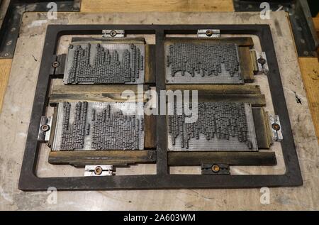 Metal plate with letters set to print a page from a reconstruction of a 16th Century printing press. Stock Photo