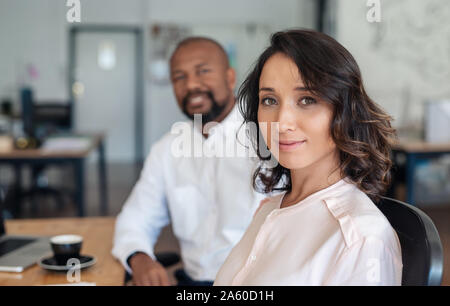 Young businesswoman sitting with a colleague in an office Stock Photo
