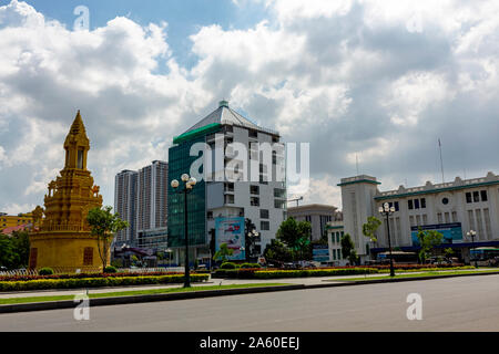 The historic gold-colored Sakhomani stupa faces the 1930's era art deco train station in the city center of Phnom Penh, Cambodia. Stock Photo