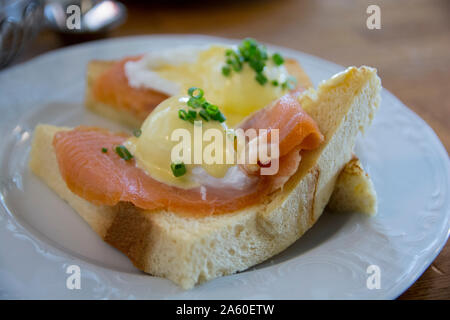 Eggs Benedict Royal, with smoked Salmon, poached eggs, Hollandaise sauce and scallion, over a fresh brioche bread. Stock Photo