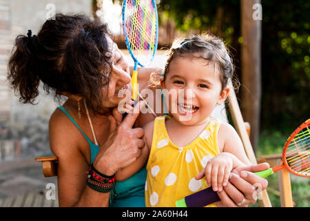 Grandmother playing with little girl and badminton rackets outdoors Stock Photo