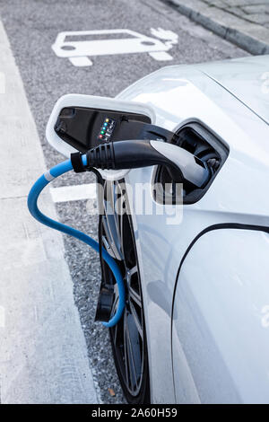 Electric car gettig charged at an charging station Stock Photo