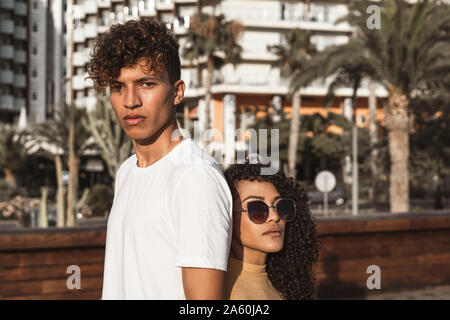 Cool couple in the city, standing back to back Stock Photo