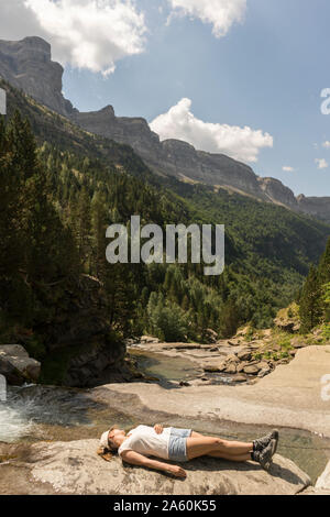 Woman lying on a rock in the mountains, Ordesa national park, Aragon, Spain Stock Photo