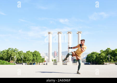 Man doing kickboxing exercise outdoors in the city Stock Photo