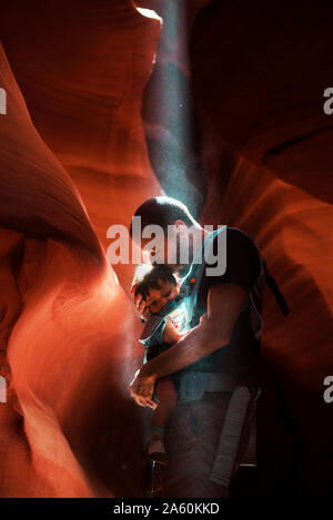 Father kissing his daughter in a baby carrier,  Antelope Canyon, Page, Arizona, United States Stock Photo