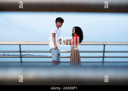 Flirting couple standing on bridge, talking Stock Photo