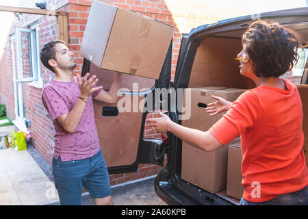 Couple unloading cardboard boxes from van Stock Photo