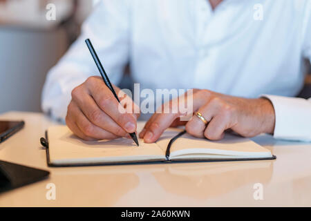 Close-up of businessman taking notes Stock Photo
