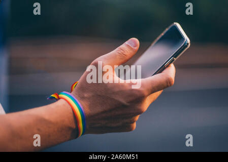 Hands of man with pusera gay flag holding an smartphone Stock Photo