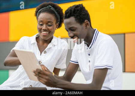 Young couple using digital tablet outdoors Stock Photo