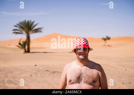 Portrait of barechested overweight man in the desert of Morocco Stock Photo