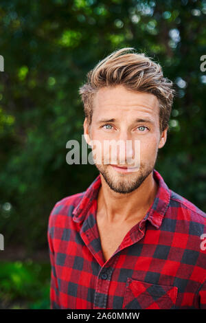 Portrait of confident young man wearing checkered shirt outdoors Stock Photo