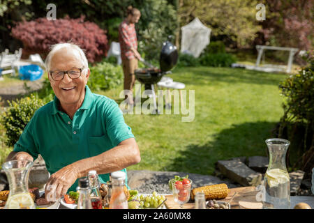 Portrait of happy senior man having lunch in garden Stock Photo