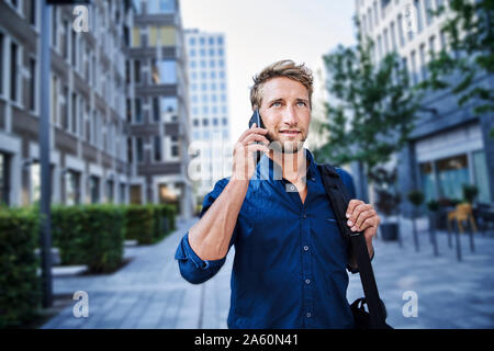 Confident young businessman on the phone in the city Stock Photo