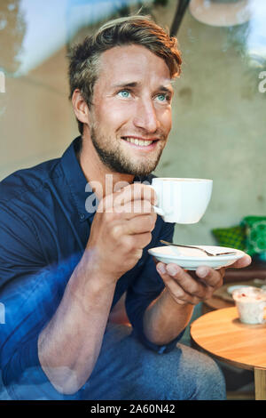 Portrait of young man drinking coffee in a cafe Stock Photo